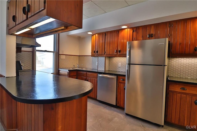 kitchen featuring decorative backsplash, stainless steel appliances, kitchen peninsula, and sink