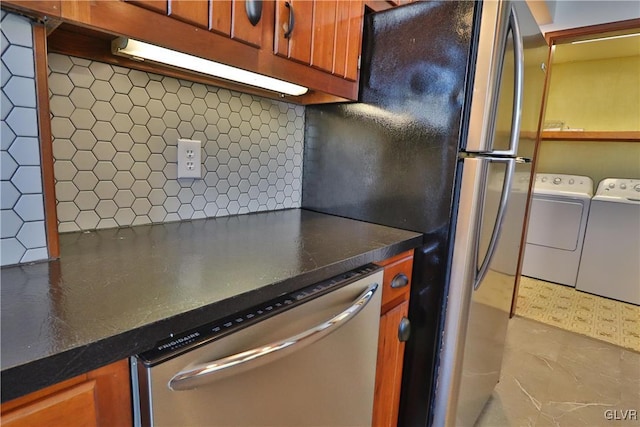 kitchen featuring washer and dryer, stainless steel appliances, and tasteful backsplash