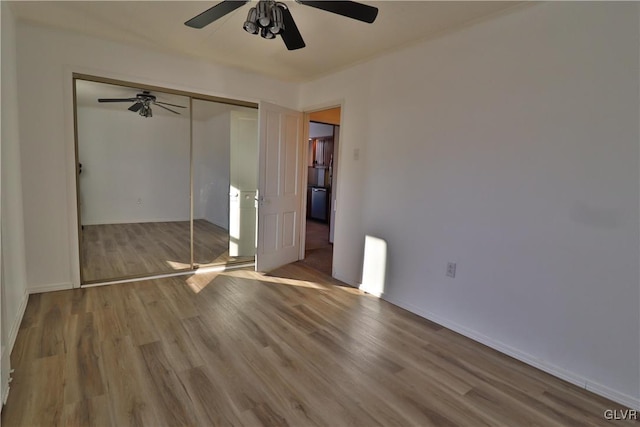 unfurnished bedroom featuring ceiling fan, light hardwood / wood-style flooring, and a closet