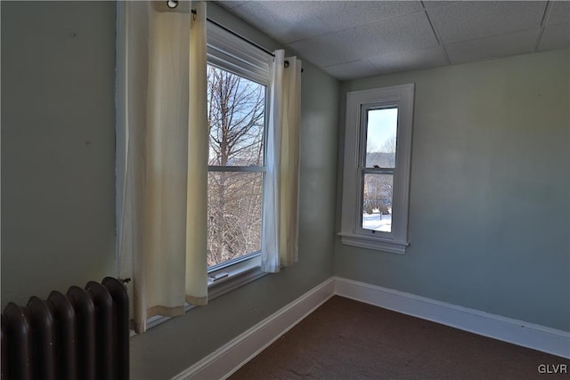 unfurnished room with a paneled ceiling and plenty of natural light