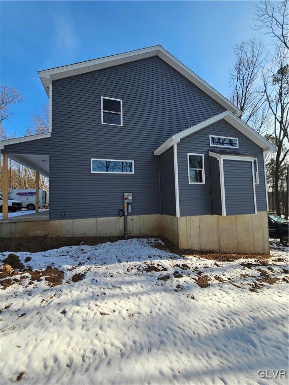 view of snow covered rear of property