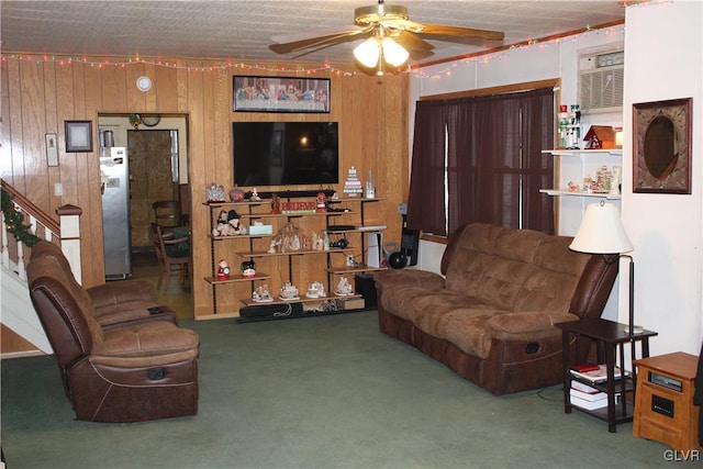 carpeted living room with an AC wall unit, ceiling fan, and wood walls