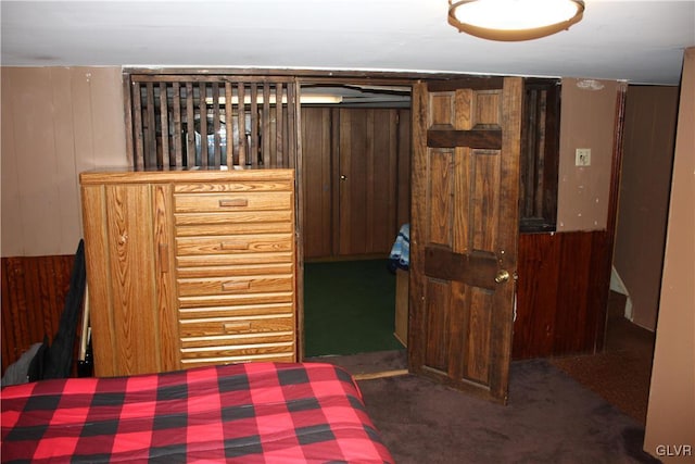 carpeted bedroom with wooden walls