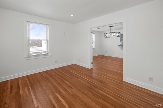 spare room with hardwood / wood-style floors and plenty of natural light