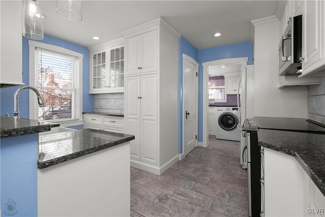 kitchen with decorative light fixtures, washer / clothes dryer, white cabinetry, and electric stove