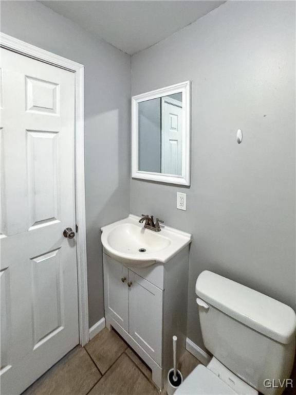 bathroom with tile patterned flooring, vanity, and toilet