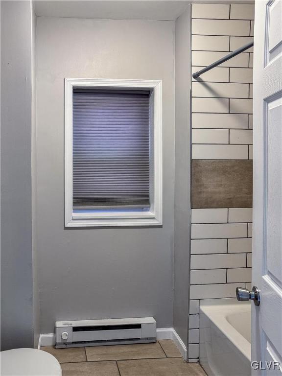 bathroom with baseboard heating, tile patterned flooring,  shower combination, and toilet