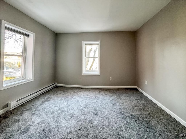 carpeted spare room with a baseboard heating unit