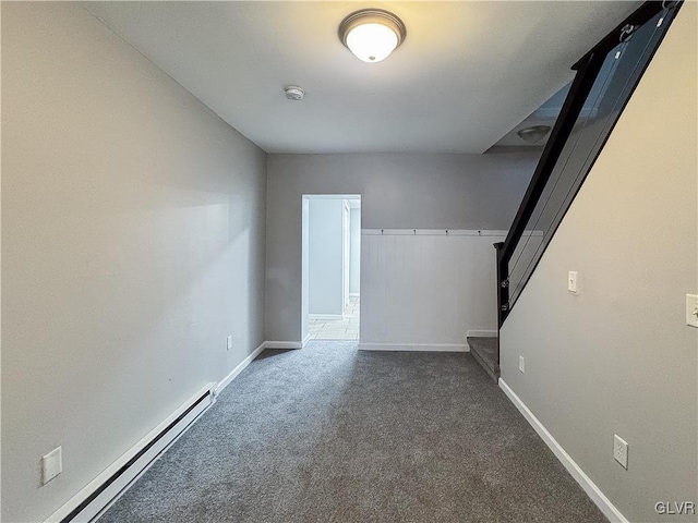 empty room with a baseboard radiator and dark colored carpet