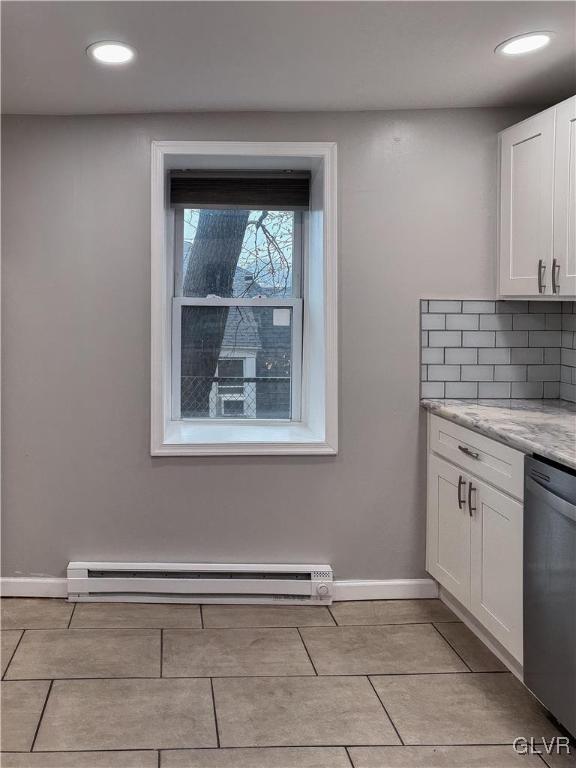 kitchen featuring white cabinetry, dishwasher, light stone countertops, a baseboard heating unit, and backsplash