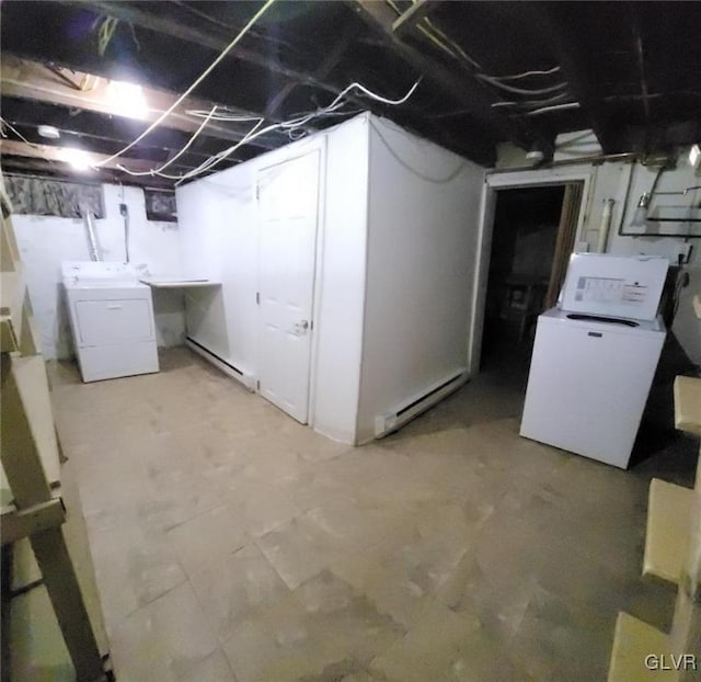 basement featuring baseboard heating and separate washer and dryer