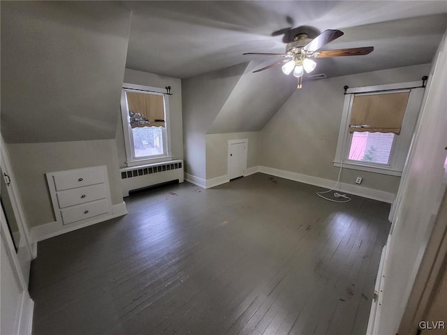 bonus room with dark hardwood / wood-style flooring, radiator, lofted ceiling, and ceiling fan