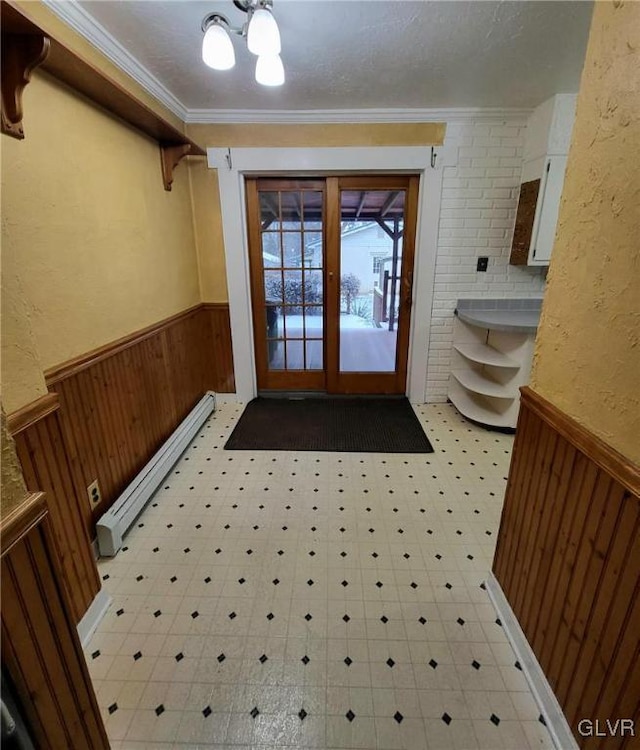 doorway to outside featuring french doors, a textured ceiling, baseboard heating, and ornamental molding