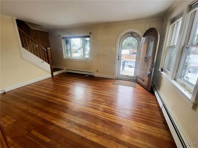 foyer entrance featuring dark wood-type flooring, a wealth of natural light, and a baseboard heating unit