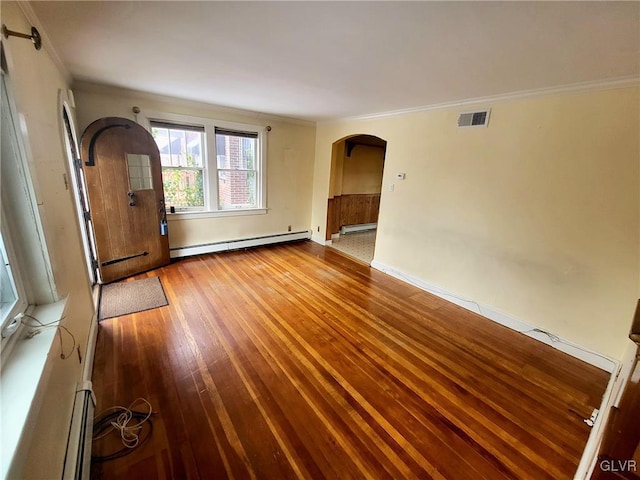 unfurnished room featuring ornamental molding, hardwood / wood-style flooring, and a baseboard heating unit