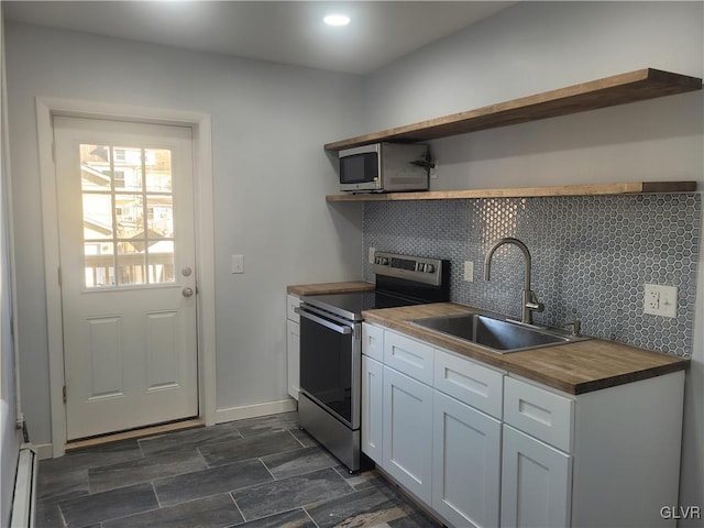 kitchen featuring sink, tasteful backsplash, wooden counters, white cabinets, and appliances with stainless steel finishes