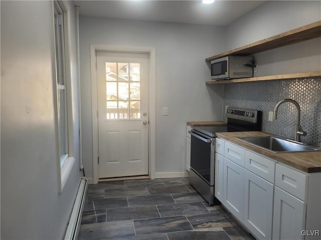 kitchen with wood counters, sink, decorative backsplash, white cabinetry, and stainless steel appliances