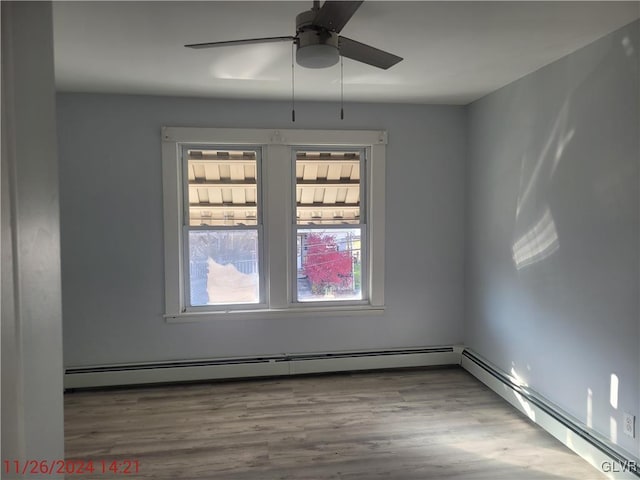 empty room featuring hardwood / wood-style floors, ceiling fan, and baseboard heating