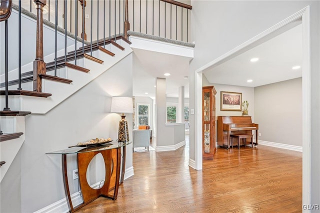 entrance foyer featuring a towering ceiling and light hardwood / wood-style flooring