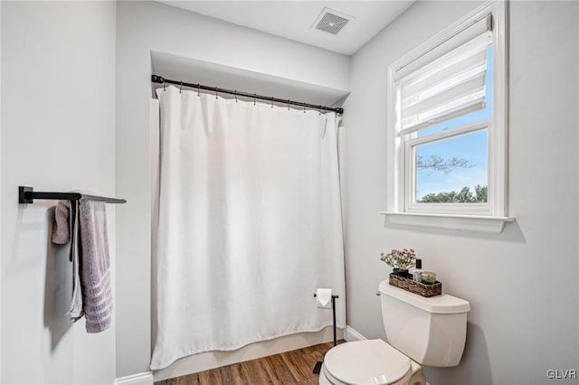 bathroom featuring a shower with curtain, hardwood / wood-style floors, and toilet