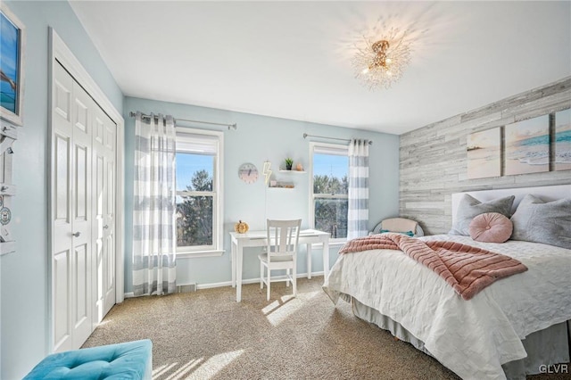 carpeted bedroom featuring a notable chandelier, a closet, and multiple windows