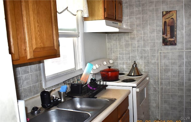 kitchen featuring decorative backsplash, white electric range, and sink