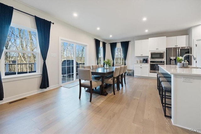 dining space with light hardwood / wood-style floors and sink