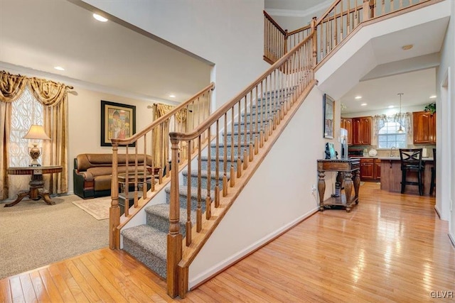 stairway featuring wood-type flooring and ornamental molding