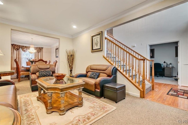 living room featuring carpet flooring, ornamental molding, and a notable chandelier