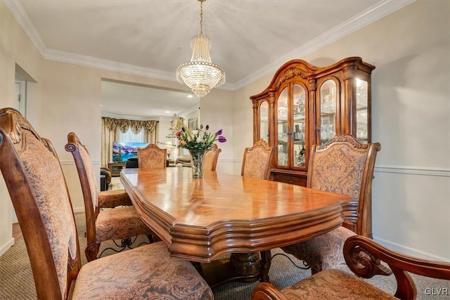 carpeted dining area featuring ornamental molding and a notable chandelier