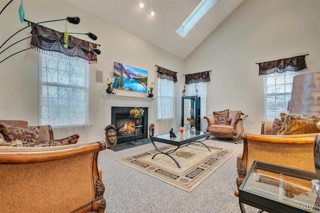 sitting room with carpet flooring, a skylight, and high vaulted ceiling