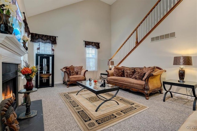 carpeted living room with high vaulted ceiling