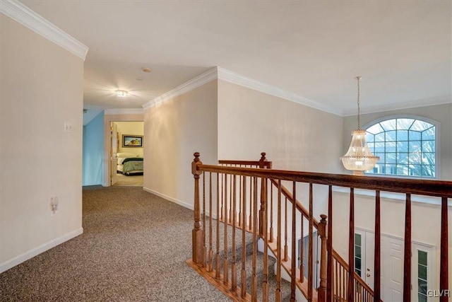 hallway with carpet, an inviting chandelier, and crown molding