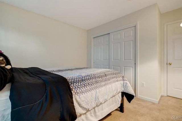 bedroom featuring light carpet and a closet