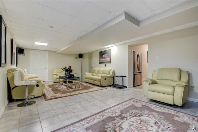 living room featuring light tile patterned floors and a paneled ceiling