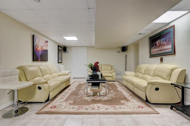 tiled living room featuring a drop ceiling