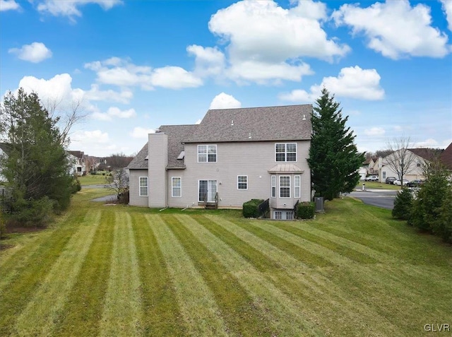 rear view of property with a yard