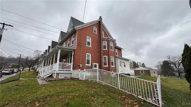 view of side of home featuring a lawn and a porch