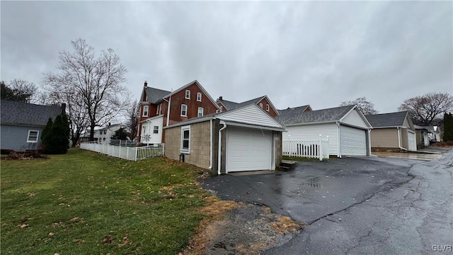 view of side of home featuring an outdoor structure, a garage, and a yard