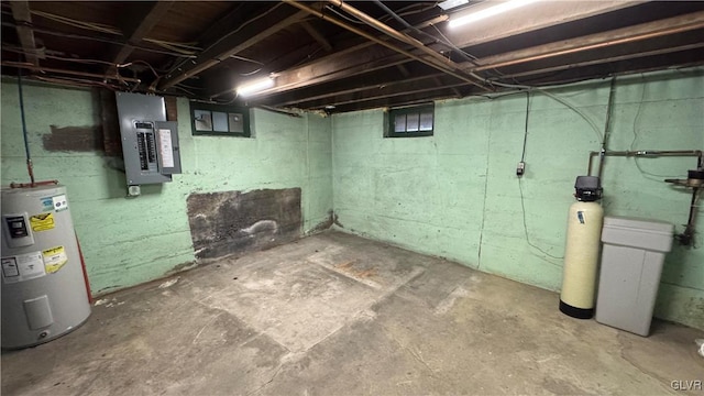 basement featuring electric panel and water heater