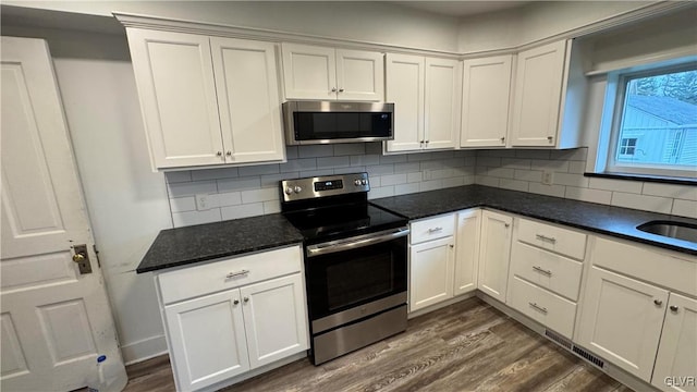 kitchen with white cabinets, decorative backsplash, and stainless steel appliances