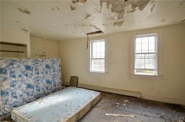 unfurnished bedroom featuring a baseboard heating unit and multiple windows