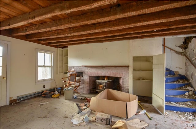 misc room featuring beam ceiling, a wood stove, and a baseboard radiator