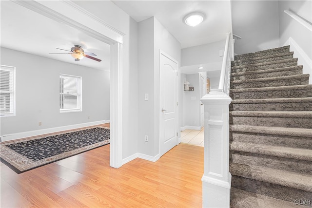 stairway with hardwood / wood-style flooring and ceiling fan