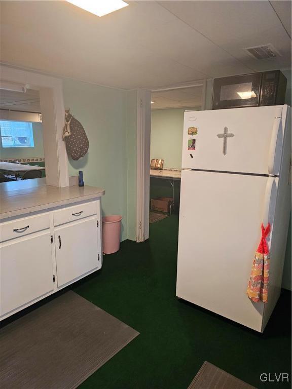 kitchen featuring white cabinetry and white refrigerator