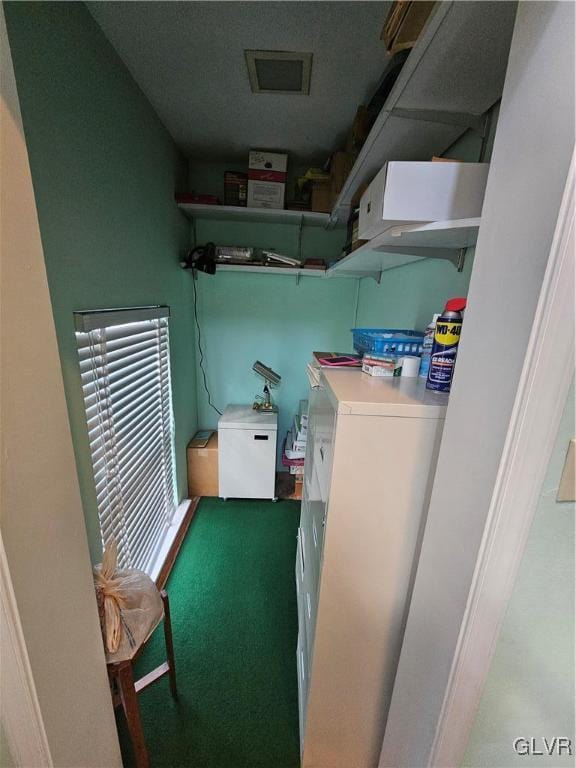 laundry area with washer and clothes dryer and light colored carpet