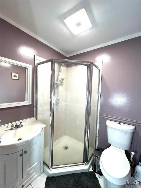 bathroom featuring crown molding, toilet, vanity, and walk in shower