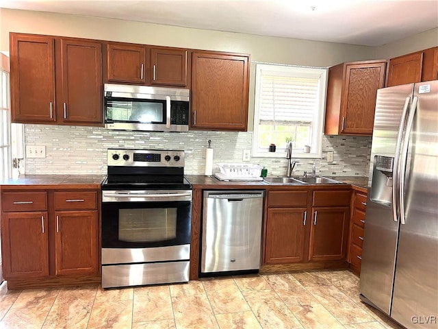 kitchen featuring decorative backsplash, sink, and appliances with stainless steel finishes