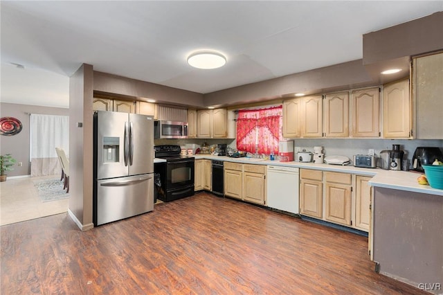 kitchen with light brown cabinetry, stainless steel appliances, dark wood-type flooring, and sink