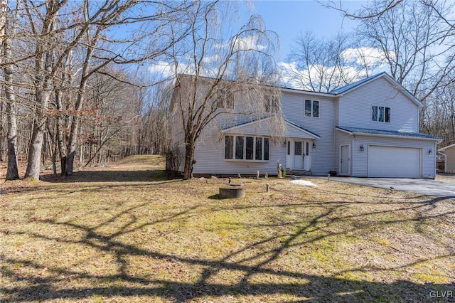 back of house with a lawn and a garage